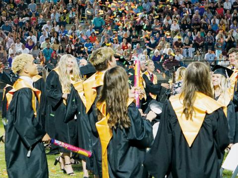 Jayden Nowell (left) and other seniors watch confetti peak and descend during  Friday’s commencement at Modeal Walsh Memorial (Big Oaks) Stadium. Robbinsville High School graduated 86 seniors at the ceremony. Photo by Randy Foster/news@grahamstar.com