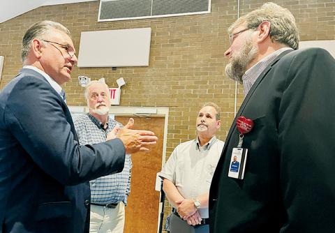 State Rep. Karl Gillespie (R-Macon), the Rev. Eric Reece, Graham County Commissioner Lynn Cody, and AdventistHealth representative Graham Fields (from left) discuss AdventHealth’s proposal to build a 67-bed hospital in Buncombe County. Graham County is within Buncombe County’s hospital service area. Photo by Randy Foster/news@grahamstar.com