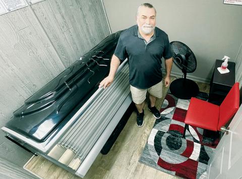 Mac Turkmen unveils one of four tanning rooms he has added to his hair and nails salon on Tallulah Road. Photo by Randy Foster/news@grahamstar.com