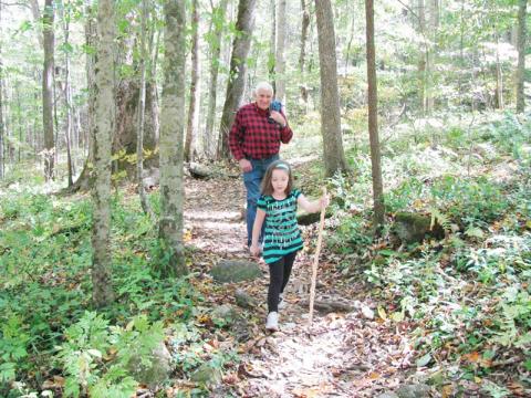 All ages enjoy the woods – including 6-year-old Simone O’Neal, shown walking a trail in Joyce Kilmer Forest with Graham Star columnist Marshall McClung in the background. Photo courtesy of Kim O'Neal/Contributing Photographer 