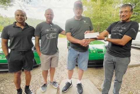 Jay Patel of Jonesboro, Ga., Chris Meaker of Charlotte, Jeff Millsaps of Graham County Rescue Squad and Mayur Malde of Sewanee, Tenn. (from left) attend a check presentation at Blue Waters Resort on Lake Santeetlah on Saturday. The group, Smokies GT, donated $5,000 to the rescue squad. Photo by Randy Foster/news@grahamstar.com