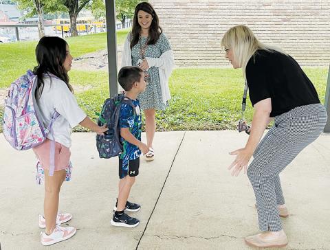 Robbinsville Elementary School faculty members Shayla Bush (background) and Lynn Lynn (right) were all smiles while greeting McKynlee Adams (left) and Maverick Ayers (center) at the beginning of the 2022-23 school year Monday. Photo by Randy Foster/news@grahamstar.com