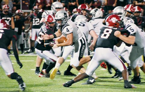 Junior running back Cuttler Adams (4) emerges from a mixture of Knights and Cougars in Friday’s season opener at Asheville. Adams finished the game with 153 rushing yards. Photos by Kevin Hensley/sports@grahamstar.com