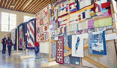 Visitors get a look at some of the many quilts on display Saturday at the Stecoah Harvest Festival. Photos by Randy Foster/news@grahamstar.com