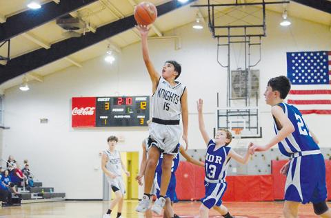 Surrounded by a flock of Eagles, Xamuel Wachacha soars toward the basket during the Nov. 3 season opener against Hiwassee Dam/Ranger. Photo by Kevin Hensley/sports@grahamstar.com