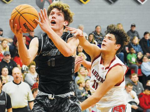 Despite the best efforts of Wildcat Cameron Rattler, Robbinsville  junior shooting guard Donovan Carpenter soars toward the net during Tuesday’s win over Andrews. Photos by Kevin Hensley/sports@grahamstar.com