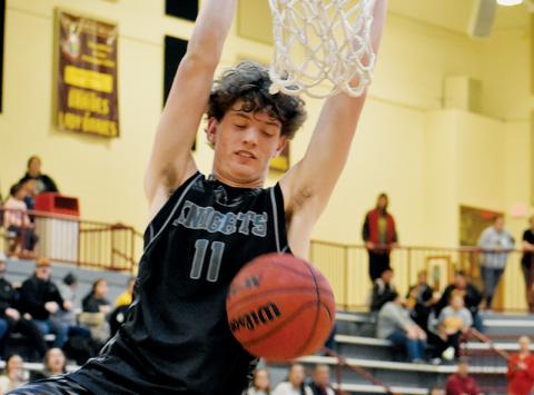 Donovan Carpenter glances down at his handiwork in the closing seconds of Tuesday’s comeback victory at Cherokee. Carpenter’s dunk resoundingly affirmed a 58-48 win for the Black Knights. Photo by Kevin Hensley/sports@grahamstar.com