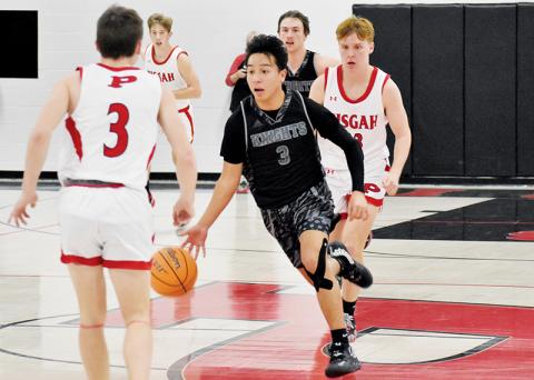 After one of his nine steals, junior shooting guard Xander Wachacha weaves between the defense of Pisgah’s Sawyer Belue (3) and Aaron Clark (back) during  Monday’s loss to the Black Bears. Wachacha had 20 points in the game, 10 of which came in transition. Photos by Kevin Hensley/sports@grahamstar.com
