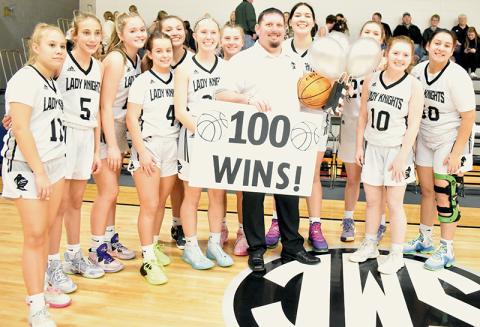 Prior to Tuesday’s home game against Blue Ridge School, the Robbinsville Lady Knights took a moment to recognize head coach Lucas Ford, who recorded his 100th win while guiding the program Jan. 3 at Hayesville. From left are Suri Watty, Anna Williams, Anna York, Desta Trammell, Katie-Lyn Gross, Kensley Phillips, Abby Wehr, Ford, Aubrie Wachacha, Liz Carpenter, Olivia Lewis and Fala Welch. Photos by Kevin Hensley/sports@grahamstar.com