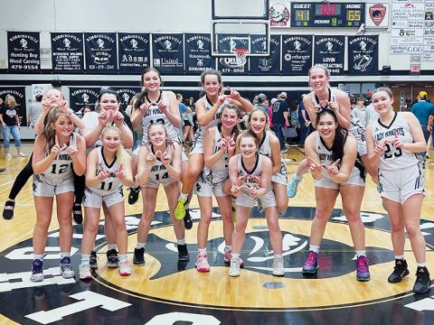 The Robbinsville Lady Knights gather for the final “W” photo they will take on their home court, after polishing off the Draughn Lady Wildcats 65-41 in the fourth round of the state playoffs. All names are listed from left. Front row: Anna York, Suri Watty, Maleah Cox, Abby Wehr, Olivia Lewis, Aubrie Wachacha and Liz Carpenter. Back row: Bella Ford, Bentley Riggins, Katie-Lyn Gross, Desta Trammell, Anna Williams and Kensley Phillips. Photo by Kevin Hensley/sports@grahamstar.com