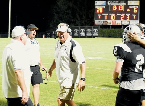 Robbinsville coaches Randy Moody, Lucas Ford and Dee Walsh (clockwise, from left) all commend senior Chase Calhoun (2) after his pivotal fourth-down tackle Friday against East Surry, which solidified a crucial goal-line stand for the Black Knights in the season-opening victory. Photo by Danielle Crabtree/The Graham Star