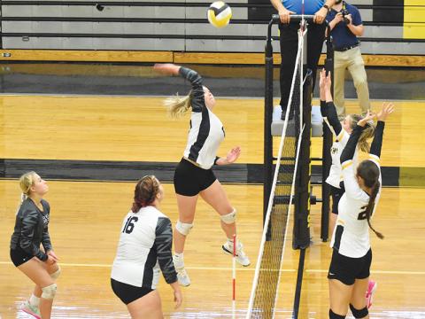 Liz Carpenter prepares to spike the ball Tuesday, as Murphy’s Cayla Greer and Lailee Holloway line up for a block attempt. Robbinsville won the first pairing between last year’s co-Smoky Mountain Conference champions in four sets. Photo by Kevin Hensley/sports@grahamstar.com