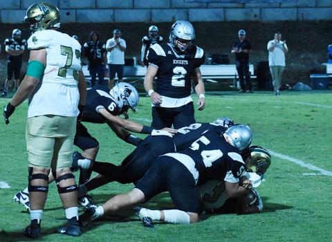 The “Black Knight Swarm” that has made waves all year – this time, compromised of Bryce Adams (6), Quinn Jumper (12), Kellen Ensley (54) and Chase Calhoun (2) – combines forces to stop Rabun Gap’s Anthony Quinn, Jr. on Friday night. Photo by Danielle Crabtree/The Graham Star