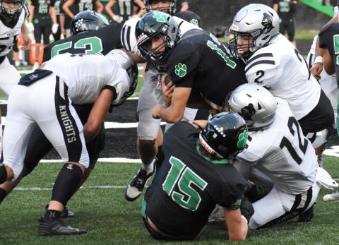 Robbinsville's Chase Calhoun (2) and Quinn Jumper (12) wrestle Mountain Heritage quarterback Brandon Quinn to the ground in the first quarter of the Black Knights' 28-17 win over the Cougars on Friday night. Photo by Kevin Hensley/sports@grahamstar.com