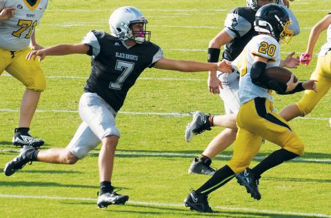 JV Black Knight Elijah Kirkland (7) attempts to slow down the efforts of Murphy’s Blake Davis on Sept. 7. Kirkland scored on the second play of Sept. 14’s road game at Andrews, which opened the floodgates in a 34-0 shutout of the Wildcats. Photo by Danielle Crabtree/The Graham Star