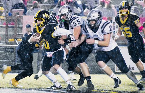 Dodging steady rainfall for much of the evening proved to be a challenge for both Robbinsville and Murphy on Friday. Here, Bulldogs quarterback Brady Grant could not get enough traction to escape Koleson Dooley (55) and Chase Calhoun (2), as the duo dropped Grant for a sack moments later. Photos by Kevin Hensley/sports@grahamstar.com