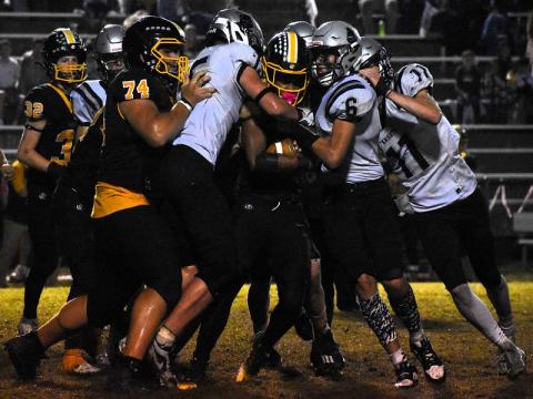 Roman Jones (15) and Bryce Adams (6) lead a sandwich of Murphy's Cameron Clem during the second half of Friday's 26-21 road victory over the Bulldogs. Photo by Kevin Hensley/sports@grahamstar.com