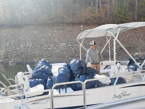 Fontana Village Marina Manager Brandon Jones helps unload trash during the Fontana Lakeshore Cleanup on Saturday. Photo by Ruby Annas/news@grahamstar.com