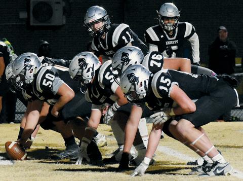 With Bryce Adams in motion, Robbinsville quarterback Donovan Carpenter lines up behind the Knights' offensive line (comprised here of Quinn Jumper, Dayne Webster, Kellen Ensley, Dane Daniels and Roman Jones, from back to front) during Friday's fourth-round playoff game against North Rowan. Consistency up front is one of the driving forces behind the Black Knights reaching the 1A Western Regional Final for the fifth time in six years. Photo courtesy of Faith Broome/Contributing Photographer