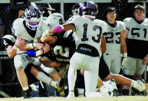 Chase Calhoun (2), Quinn Jumper (12) and Kellen Ensley drop Swain County's Joshua Collins for a loss during Robbinsville's 30-24, third-round playoff victory Friday. Photo by Fala Welch/The Graham Star
