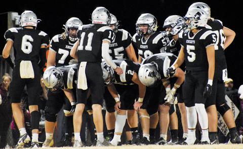 Senior quarterback Donovan Carpenter gives instruction to the Robbinsville Black Knights’ offense prior to a first-half play in the third round of the 1A state playoffs Friday against Swain County. Carpenter heavily credited the perseverance of the Knights in the 30-24 win to the program’s main theme this year: “brotherhood.” Photo by Fala Welch/The Graham Star