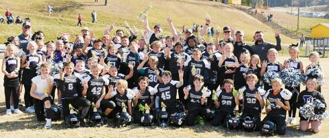 The Robbinsville Mites make it official Saturday, gathering around the 2023 Cracker Bowl Championship trophy to soak up the moment after winning their fourth title in a row. Photo by Kevin Hensley/sports@grahamstar.com