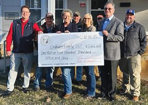 Senate 50 Rep. Kevin Corbin (left, holding check, R-Franklin) and District 120 Rep. Karl Gillespie (right, holding check, R-Franklin) spent several hours in Graham County on Dec. 20, presenting checks for various needs across the county. The tour began at the N.C. Department of Transportation’s office, where a check in the amount of $1.4 million was awarded. Photo courtesy of Kevin Corbin