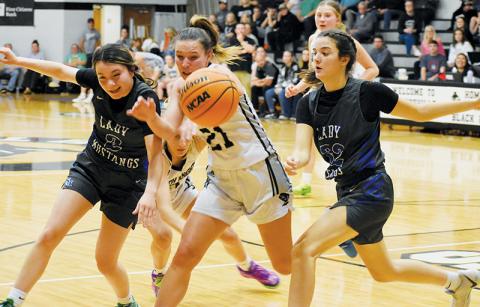 Robbinsville’s Delaney Brooms (21) jostles with Smoky Mountain’s Kieara Ensley (2) and Julia Macauley over a rebound during the Lady Knights’ win over the Lady Mustangs on Dec. 7. Photos by Fala Welch/The Graham Star
