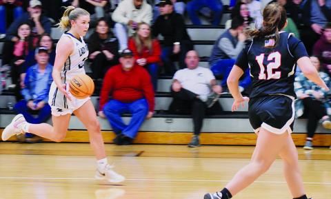 With Andrews’ Kinleigh Queen (12) sprinting to cut off the progress, Liz Carpenter breaks toward the home basket during Tuesday’s loss to the Lady Wildcats. Despite Carpenter’s 21-point showing, the Knights suffered their first setback of the season. Photo by Fala Welch/The Graham Star