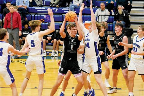 Forward Bryce Adams fights through the interior defense of Smoky Mountain’s Cameron Fowler (5) and Ace Pregner (14) on Dec. 27. Although the junior’s efforts in the game resulted in a double-double, the Black Knights suffered their first loss of the year. Photos by Fala Welch/The Graham Star