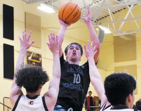 Junior forward Bryce Adams rises above the defense of Cherokee’s Savian Davis (12) and Samuel Hernandez (10) for a second-half basket Tuesday. Including Adams, four Robbinsville players scored in double digits – but could not stop the Braves from winning the Smoky Mountain Conference title. Photos by Kevin Hensley/sports@grahamstar.com