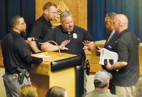 Civility went out the window late in the March 21 public forum to discuss a potential change of jurisdiction for school resource officers. Robbinsville Elementary School SRO Josh Reap (left) and Graham County Sheriff’s Office attorney David Wijewickrama (right, in suit) got into a heated argument. Standing between the two are Robbinsville Middle/High School SRO Jeff Knight; Sheriff Brad Hoxit is at far right, and the chief of detectives, Travis Brooks, is walking behind Knight. Photo by Kevin Hensley