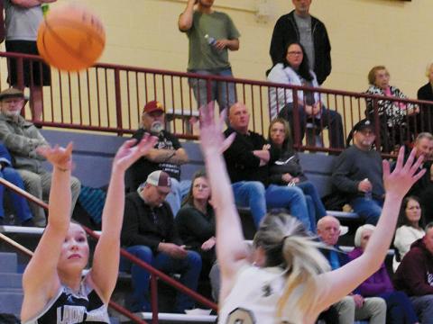 Robbinsville senior Delaney Brooms unloads a 3-point attempt over the defense of Hayesville’s Emma Ashe during Feb. 20’s meeting in the semifinals of the conference tournament. The Knights and Jackets were paired together in the first round of the playoffs exactly one week later, with Hayesville pulling away late to advance in the postseason race. Photo by Kevin Hensley/sports@grahamstar.com