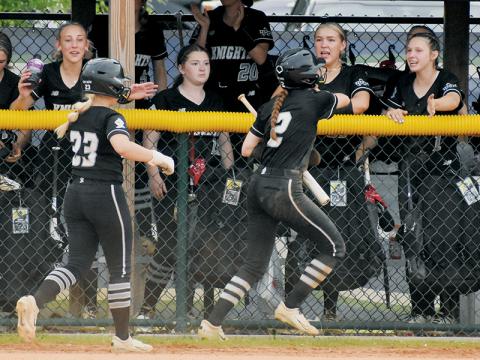 Robbinsville’s Suri Watty (23) and Zoie Shuler (2) run down a line of high-fives from teammates Anna Williams, Liz Carpenter and Delaney Brooms (from left), after Shuler scored the second run of Friday’s fourth-round playoff win at Uwharrie Charter. Photos by Kevin Hensley/sports@grahamstar.com
