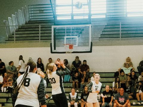 Senior Liz Carpenter (20) prepares for a pass to freshman Daphne Barlow (5) during Aug. 12’s season opener against T.C. Roberson. Photo by Royce Worbington/The Graham Star