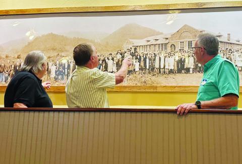 Larry Paige, Billy Cable and Dwight Bradshaw (from left) look at the 1926 dedication photo of Stecoah School inside the auditorium at Saturday’s annual reunion. Photos by Latresa Phillips/The Graham Star