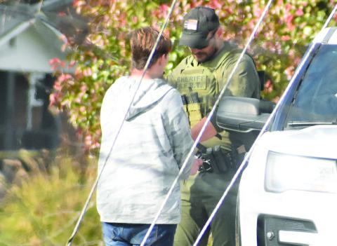 Graham County Sheriff's Office Deputy Jarod Lovelace encounters one of the individuals authorities were searching for around 1 p.m., Tuesday, as part of "Operation Dirty Laundry: Phase 2." The suspect was apprehended just outside the Robbinsville city limits, after being spotted on foot walking north off U.S. Highway 129 (Tapoco Road). Photo by Kevin Hensley/editor@grahamstar.com