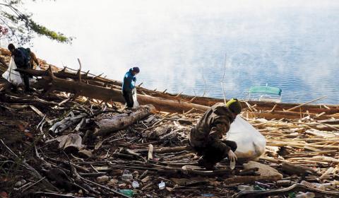 As a mist rises off the water, volunteers sift through garbage strewn about a bank that normally is underwater during warm months on Fontana Lake during last month’s clean-up. Photos courtesy of Brandon Jones/Fontana Village Marina