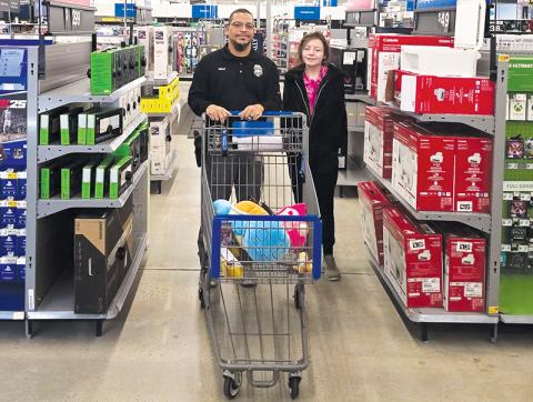 Graham County’s officers took local children to the  Murphy Walmart for the annual “Shop with a Cop” on Dec. 11. Here, Robbinsville Elementary School  Resource Officer Josh Reap helps a member of the program gather Christmas presents. Photo courtesy of Graham County Sheriff's Office