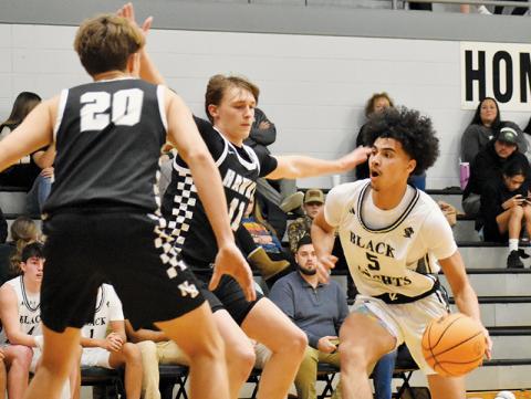 Senior Darion Ledbetter (5) works into the paint and looks to split the defense of North Buncombe’s Cole Edmonds (11) and Tripp Switzer (20) on Jan. 8. Photo by Jacquline Gayosso/The Graham Star