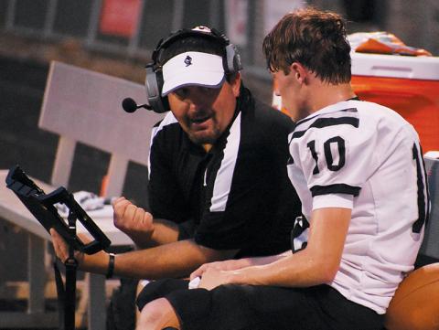 Lucas Ford reviews a play with Tanner Hedden during Aug. 30’s game at Franklin. Ford’s rapport with the players had many of the Robbinsville faithful pulling for the Black Knight alum to be appointed as the new head football coach; Feb. 6, he was announced as Dee Walsh’s successor. Photo by Kevin Hensley/sports@grahamstar.com