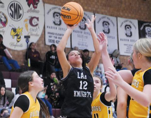 Middle school Lady Knight Aaliyah Wolfe splits a pair of Murphy defenders to unload a second-half jumper during Jan. 29’s conference-tournament semifinals. Photos by Kevin Hensley/sports@grahamstar.com