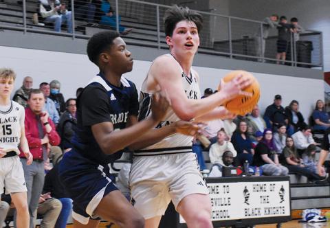 Robbinsville senior Roman Jones tries to shirk a Bradford Prep defender while  charging toward the basket during Tuesday’s first-round playoff game. Photo by Bella Eddings/The Graham Star
