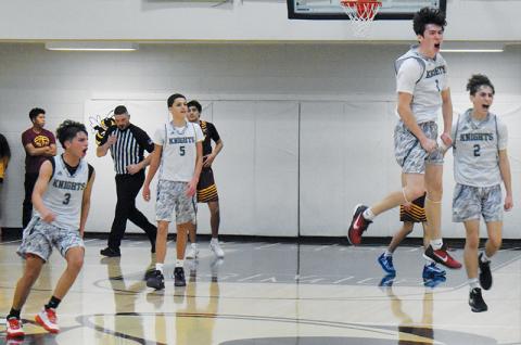 Moments after the final buzzer sounded Saturday, JV Black Knights Xamuel Wachacha (3), Tucker Jones (5), Bam Nelms (1) and Eli Lambert (2) begin to celebrate Robbinsville’s Smoky Mountain Conference tournament-title victory. Photos by Kevin Hensley/sports@grahamstar.com