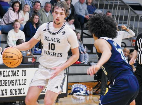 Bryce Adams looks for a way to evade the defense of Bradford Preparatory  Academy’s Isaiah Poston during the first round of the state playoffs Feb. 25. Adams was recently named the Smoky Mountain Conference Boys Player of the Year. Photo by Bella Eddings/The Graham Star