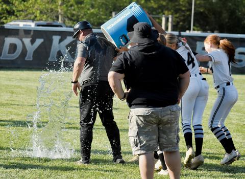 Robbinsville head coach Billy Knight receives a customary bath Monday, after leading the Lady Knights to their 17th Smoky Mountain Conference title. Delivering the free shower were Loxley Burke (not visible), Anna Williams (4) and Kynadee Spencer (1). Photo by Bella Eddings/The Graham Star