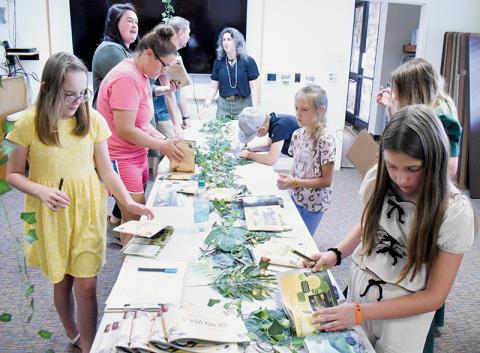 Students from Robin Welker’s third-grade class clamor around a table inside the Graham County Public Library on June 10, to sign copies of their self-produced Graham County Field Guide. Photos by Kevin Hensley/editor@grahamstar.com