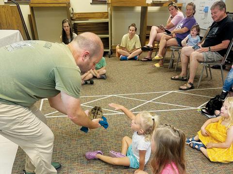 Naomi Buchanan reaches to pet “Trevor” during June 5’s Wildlife Wonders exhibition at the Graham County Public Library. Photos by Latresa Phillips/The Graham Star