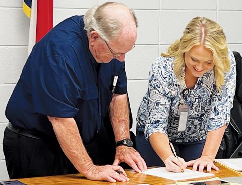 Board of Education Chair Rodney Nelson (left) and Commission Chair Meggan Smith were all smiles while signing a contract  Tuesday, which allows the county to purchase school-owned land to build a justice center. Photos by Kevin Hensley/editor@grahamstar.com