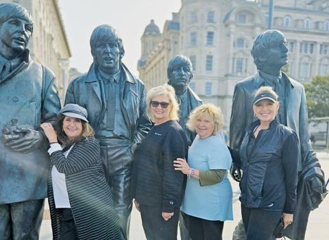 Latresa Phillips, Barbie Adams, Pricella Andrews-Maury and Kim Waldroup (from left) pose with Beatles statutes during the writer's overseas trip earlier this month.